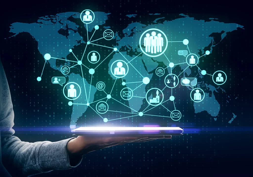 Mano sosteniendo una tableta de la que surge un mapa mundial con iconos de usuarios conectados